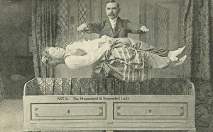 Nita, the hypnotized and suspended lady, magician performing a levitation trick Nita, the hypnotized and suspended lady, magician performing a levitation trick