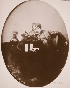 Frustration Prints: Thomas A. Edison sitting by his improved machine, 1889 (sepia photo)